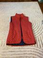 veste sans manche rose (elle parait rouge sur la photo mais elle est rose !)